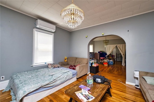 62 School St, Fall River, MA 02720 - bedroom with a wall mounted AC, arched walkways, ornamental molding, wood finished floors, and a chandelier