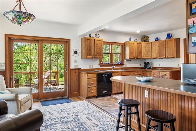 201 Paradise Ave, Middletown, RI 02842 - kitchen with dishwasher, a sink, a kitchen bar, open floor plan, and brown cabinets