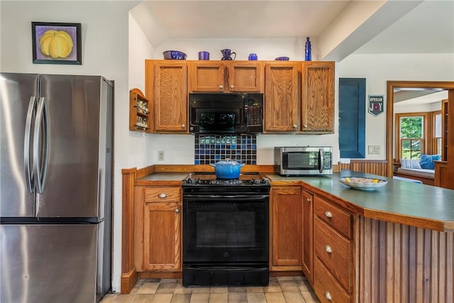 201 Paradise Ave, Middletown, RI 02842 - kitchen featuring black appliances, a peninsula, brown cabinetry, and dark countertops
