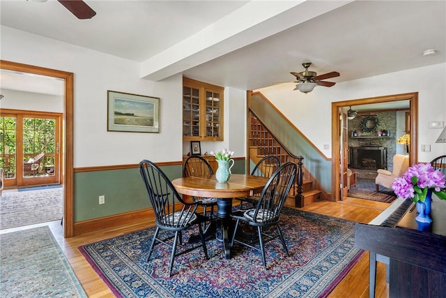 201 Paradise Ave, Middletown, RI 02842 - dining room featuring ceiling fan, stairway, a fireplace, light wood-type flooring, and baseboards