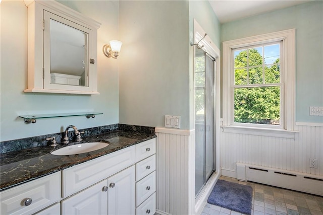 201 Paradise Ave, Middletown, RI 02842 - bathroom featuring baseboard heating, wainscoting, vanity, and a stall shower