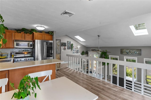 68 Everglade Ave, Warwick, RI 02886 - kitchen with a skylight, stainless steel appliances, wood finished floors, light countertops, and vaulted ceiling