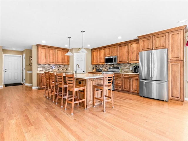 162 Pine Orchard Rd, Glocester, RI 02814 - kitchen with appliances with stainless steel finishes, brown cabinetry, recessed lighting, a kitchen breakfast bar, and light wood finished floors