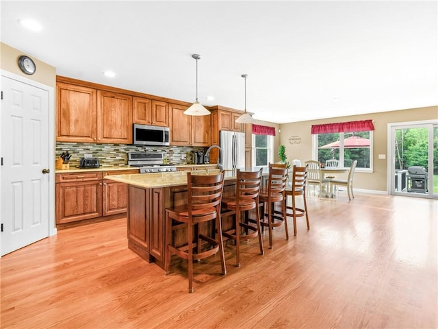 162 Pine Orchard Rd, Glocester, RI 02814 - kitchen with stainless steel appliances, light wood-type flooring, brown cabinets, a center island with sink, and recessed lighting
