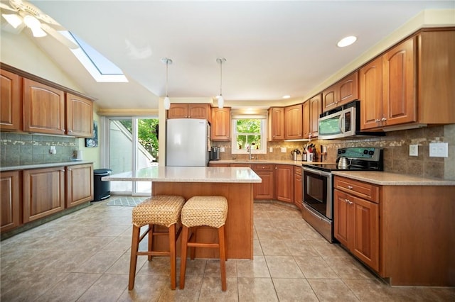 79 Pilgrim Dr, Warwick, RI 02888 - kitchen with stainless steel appliances, a kitchen bar, tasteful backsplash, a skylight, and a sink