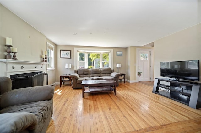 79 Pilgrim Dr, Warwick, RI 02888 - living area with light wood finished floors, baseboards, plenty of natural light, and a fireplace