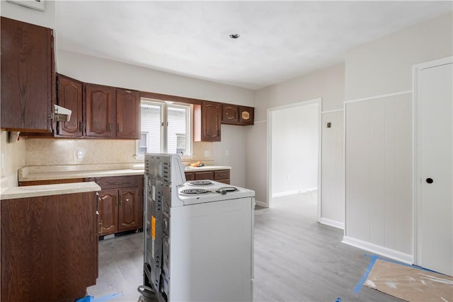 35 Laurel St, Pawtucket, RI 02860 - kitchen with electric stove, light wood-type flooring, light countertops, decorative backsplash, and a kitchen island