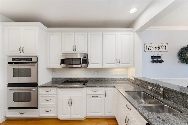 83 Waters Edge St Unit 24, Tiverton, RI 02878 - kitchen with stainless steel appliances, a sink, white cabinets, and dark stone counters