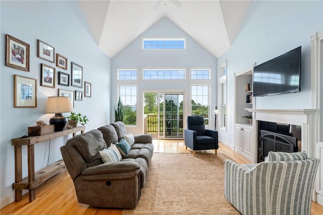 83 Waters Edge St Unit 24, Tiverton, RI 02878 - living area with wood finished floors, a fireplace, ceiling fan, high vaulted ceiling, and baseboards