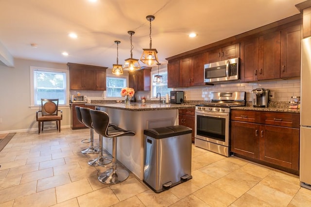 21 Baldwin Rd, Warwick, RI 02886 - kitchen featuring appliances with stainless steel finishes, decorative backsplash, a kitchen breakfast bar, plenty of natural light, and recessed lighting
