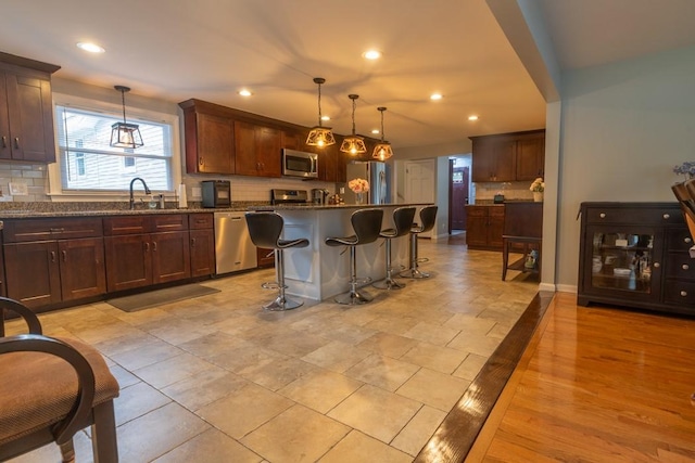 21 Baldwin Rd, Warwick, RI 02886 - kitchen featuring appliances with stainless steel finishes, backsplash, a breakfast bar, pendant lighting, and recessed lighting