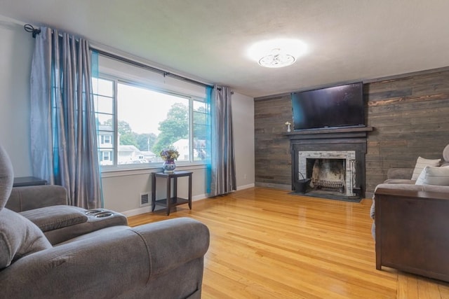 21 Baldwin Rd, Warwick, RI 02886 - living room featuring light wood-type flooring, a fireplace, baseboards, and wooden walls