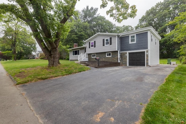 21 Baldwin Rd, Warwick, RI 02886 - view of front of home with asphalt driveway, stone siding, an attached garage, a front lawn, and a chimney