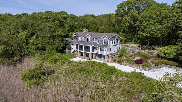 137 Cove Pt E, Charlestown, RI 02813 - rear view of house with a forest view, a balcony, a chimney, and a wooden deck
