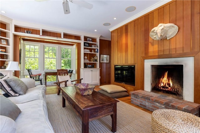 137 Cove Pt E, Charlestown, RI 02813 - living area with a brick fireplace, wooden walls, ornamental molding, built in features, and wood finished floors