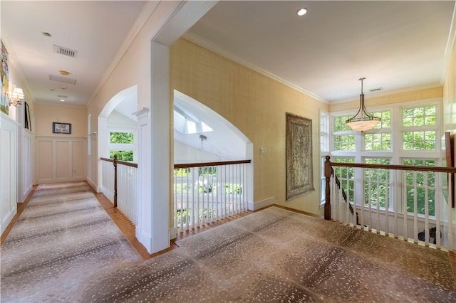 137 Cove Pt E, Charlestown, RI 02813 - hall with arched walkways, an upstairs landing, and crown molding