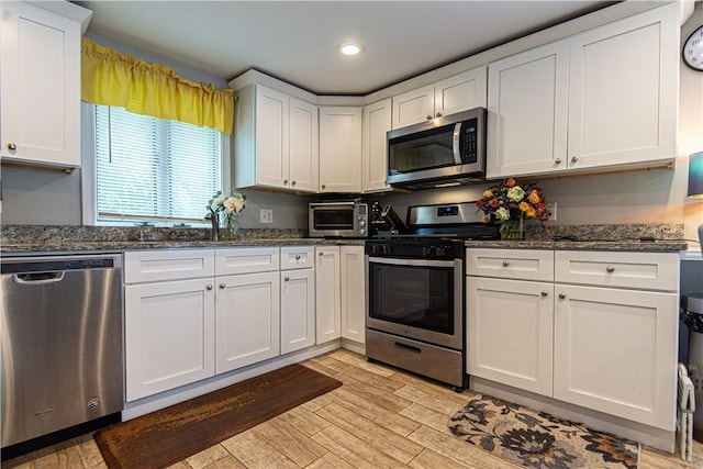 34 Zambarano Ave, North Providence, RI 02911 - kitchen with stainless steel appliances, light wood-type flooring, white cabinetry, dark stone countertops, and recessed lighting