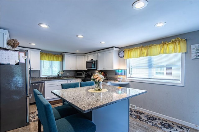 34 Zambarano Ave, North Providence, RI 02911 - kitchen featuring stainless steel appliances, recessed lighting, a breakfast bar area, white cabinetry, and light stone countertops