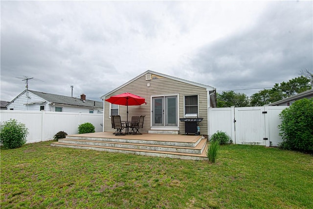 34 Zambarano Ave, North Providence, RI 02911 - back of property featuring a gate, a wooden deck, a fenced backyard, and outdoor dining space