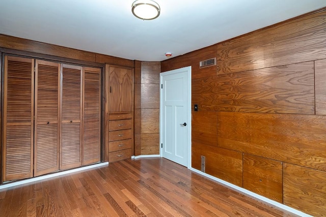 137 Rocky Hill Rd, Scituate, RI 02857 - unfurnished bedroom featuring wood finished floors, a closet, and wood walls