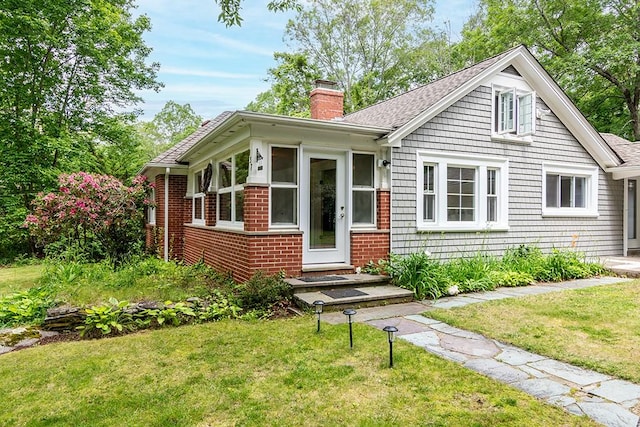 137 Rocky Hill Rd, Scituate, RI 02857 - bungalow-style house featuring a chimney, a front yard, roof with shingles, and brick siding