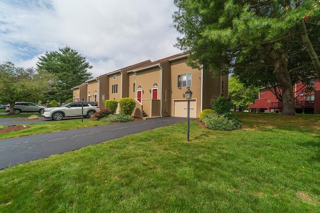 7 Tamarac Dr Unit F, Smithfield, RI 02828 - view of front facade with asphalt driveway, a front yard, an attached garage, and stucco siding