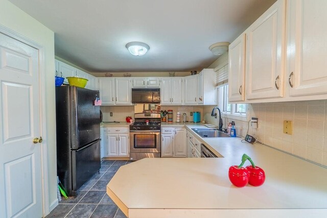 7 Tamarac Dr Unit F, Smithfield, RI 02828 - kitchen featuring stainless steel appliances, light countertops, dark tile patterned flooring, backsplash, and a peninsula