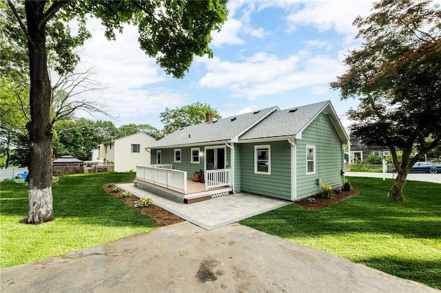 65 Harrop Ave, Warwick, RI 02886 - view of front facade featuring a deck, a front yard, a shingled roof, and a patio