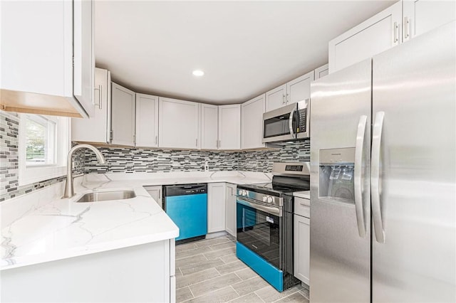 65 Harrop Ave, Warwick, RI 02886 - kitchen with stainless steel appliances, light stone countertops, decorative backsplash, light wood finished floors, and recessed lighting