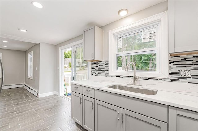 65 Harrop Ave, Warwick, RI 02886 - kitchen featuring decorative backsplash, light stone countertops, recessed lighting, light wood-type flooring, and baseboard heating