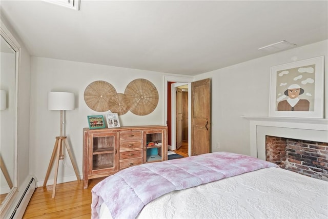 35 Second St, Newport, RI 02840 - bedroom with baseboard heating, light wood-style floors, and a fireplace