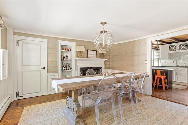 35 Second St, Newport, RI 02840 - dining space featuring a baseboard radiator, wood finished floors, a fireplace, ornamental molding, and a chandelier