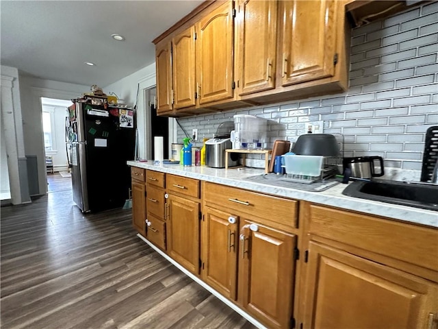25 Eddy St, West Warwick, RI 02893 - kitchen with freestanding refrigerator, dark wood-type flooring, light countertops, decorative backsplash, and brown cabinets