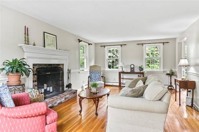 373 Fletcher Rd, North Kingstown, RI 02852 - living room featuring light wood-type flooring, a fireplace, and a baseboard heating unit