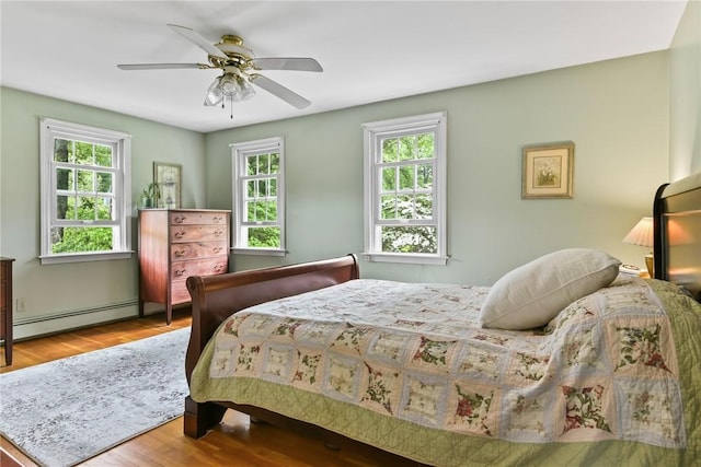 373 Fletcher Rd, North Kingstown, RI 02852 - bedroom with a baseboard heating unit, wood finished floors, and a ceiling fan