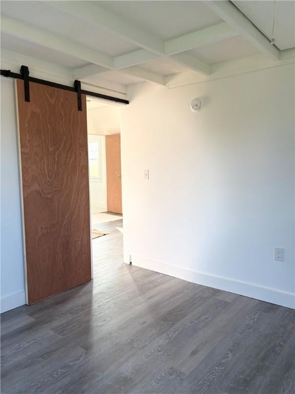 854 Matunuck Beach Rd, South Kingstown, RI 02879 - spare room with wood finished floors, beamed ceiling, a barn door, a smoke detector, and coffered ceiling