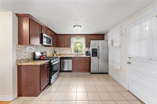 59 Massachusetts Ave, Warwick, RI 02888 - kitchen with appliances with stainless steel finishes, backsplash, light stone countertops, and light tile patterned floors