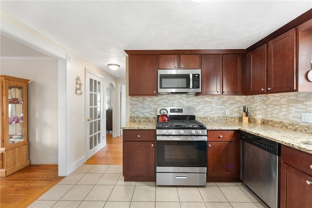 59 Massachusetts Ave, Warwick, RI 02888 - kitchen with appliances with stainless steel finishes, tasteful backsplash, light wood-style flooring, light stone countertops, and ornamental molding