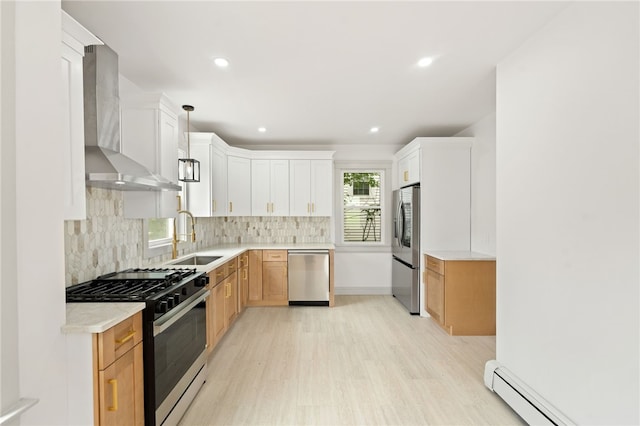 1314 Chalkstone Ave, Providence, RI 02908 - kitchen featuring appliances with stainless steel finishes, a baseboard radiator, wall chimney exhaust hood, light wood-style flooring, and light countertops