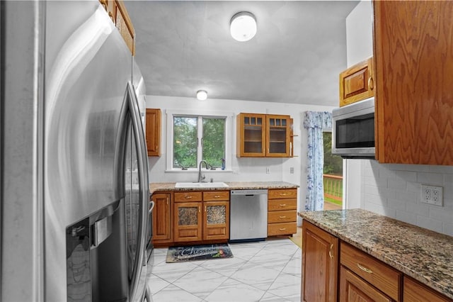 2 Birch St, Johnston, RI 02919 - kitchen with stainless steel appliances, brown cabinetry, backsplash, light stone countertops, and glass insert cabinets