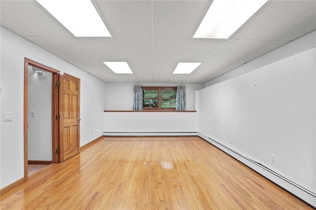 2 Birch St, Johnston, RI 02919 - empty room featuring baseboard heating, light wood finished floors, a drop ceiling, and a baseboard heating unit
