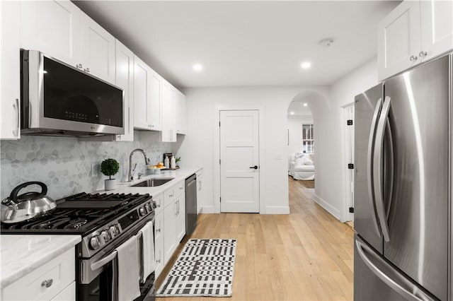 51 Poplar St Unit 1L, Newport, RI 02840 - kitchen with stainless steel appliances, white cabinetry, decorative backsplash, light wood-type flooring, and recessed lighting
