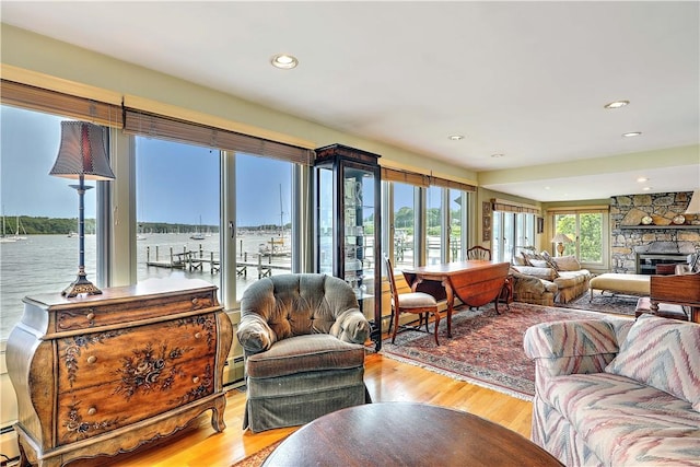 8 Alger Ave, Warwick, RI 02818 - living room featuring wood finished floors, a fireplace, a water view, recessed lighting, and baseboard heating