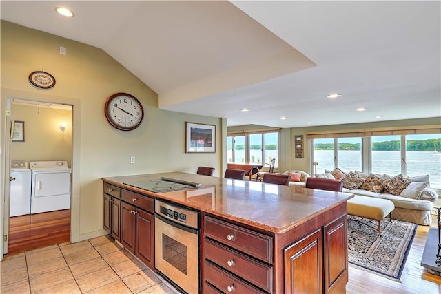 8 Alger Ave, Warwick, RI 02818 - kitchen with stainless steel oven, independent washer and dryer, a peninsula, open floor plan, and a water view