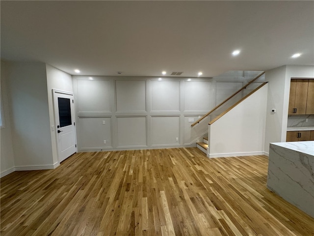 12 Daggett Ct Unit 2, Providence, RI 02906 - below grade area with a decorative wall, light wood-type flooring, stairs, and recessed lighting