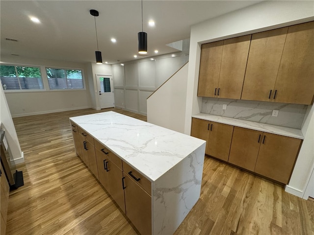 12 Daggett Ct Unit 2, Providence, RI 02906 - kitchen with light wood finished floors, brown cabinetry, a kitchen island, pendant lighting, and recessed lighting