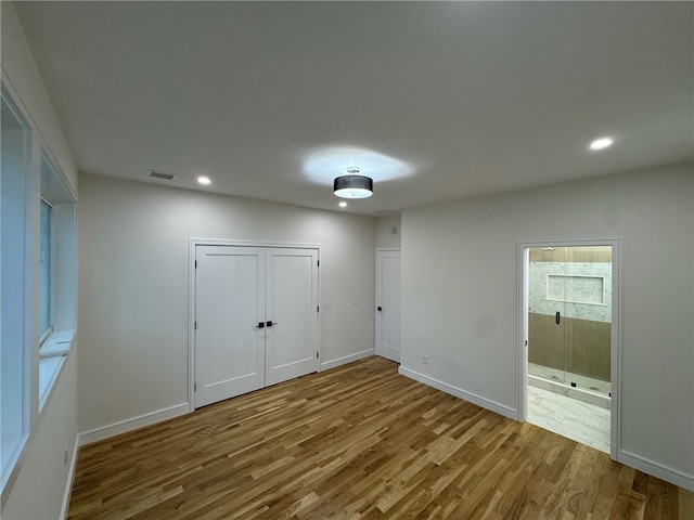 12 Daggett Ct Unit 2, Providence, RI 02906 - unfurnished bedroom with wood finished floors, recessed lighting, connected bathroom, and a closet