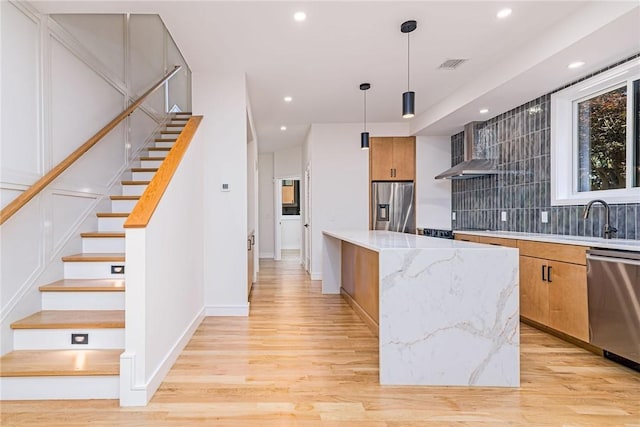 12 Daggett Ct Unit 2, Providence, RI 02906 - kitchen featuring stainless steel appliances, wall chimney exhaust hood, light wood finished floors, tasteful backsplash, and recessed lighting