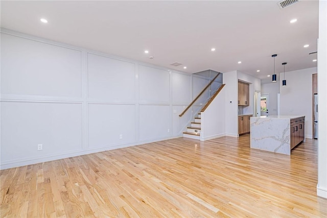 12 Daggett Ct Unit 2, Providence, RI 02906 - unfurnished living room featuring a decorative wall, light wood-style floors, stairway, and recessed lighting