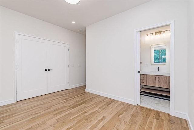 12 Daggett Ct Unit 2, Providence, RI 02906 - unfurnished bedroom with light wood-style floors, ensuite bathroom, and a closet